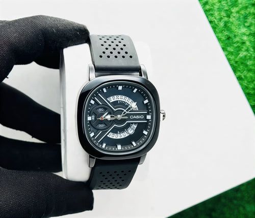 Casio watch held by a gloved hand on a white and green background
